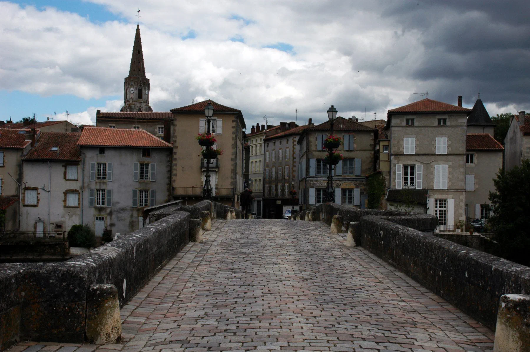 Le vieux pont pavé de Confolens et les façades de la vieille ville, dominées par un clocher